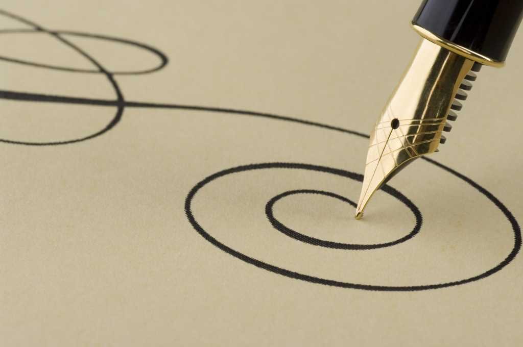 An elegant spiral pattern written in black ink on paper by a gold-tipped fountain pen.
